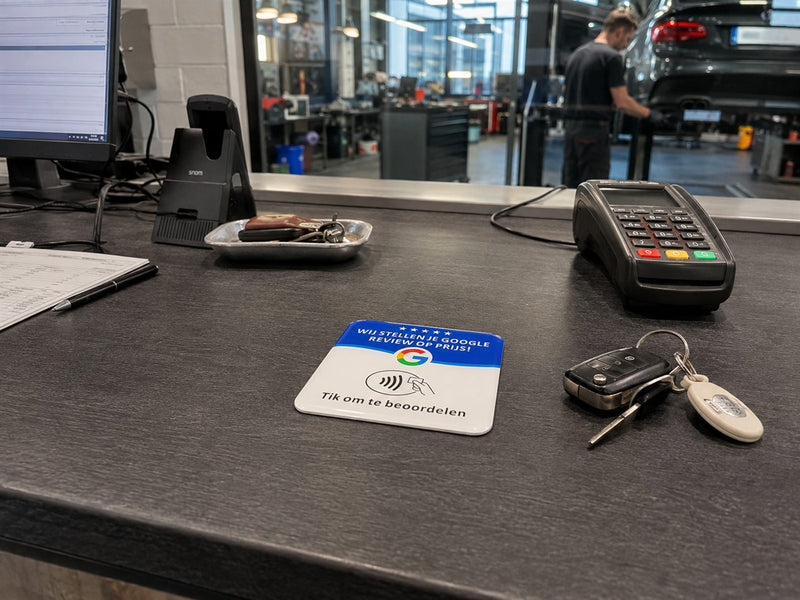 Reviewtje baliebordje op de receptiebalie van een autobedrijf